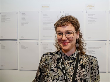 Former Magnify Artist in Residence and Artz Blitz award winner, Maja Irene Bolier standing in front of written works.