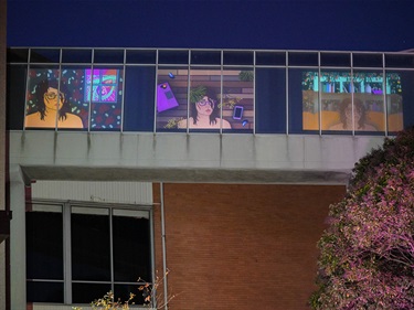 Photo of a video projection of Jarra Karalinar Steel's artworks onto the outside of Kingston's disused pedestrian bridge at night