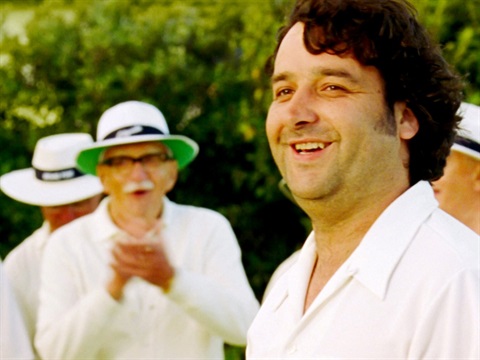 Men in white bowls uniform stand in a group 