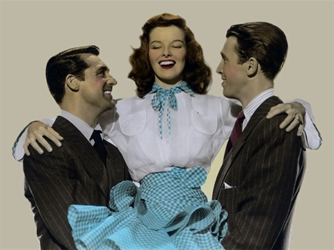 Two men carry a woman who is laughing and wearing a blue checkered skirt