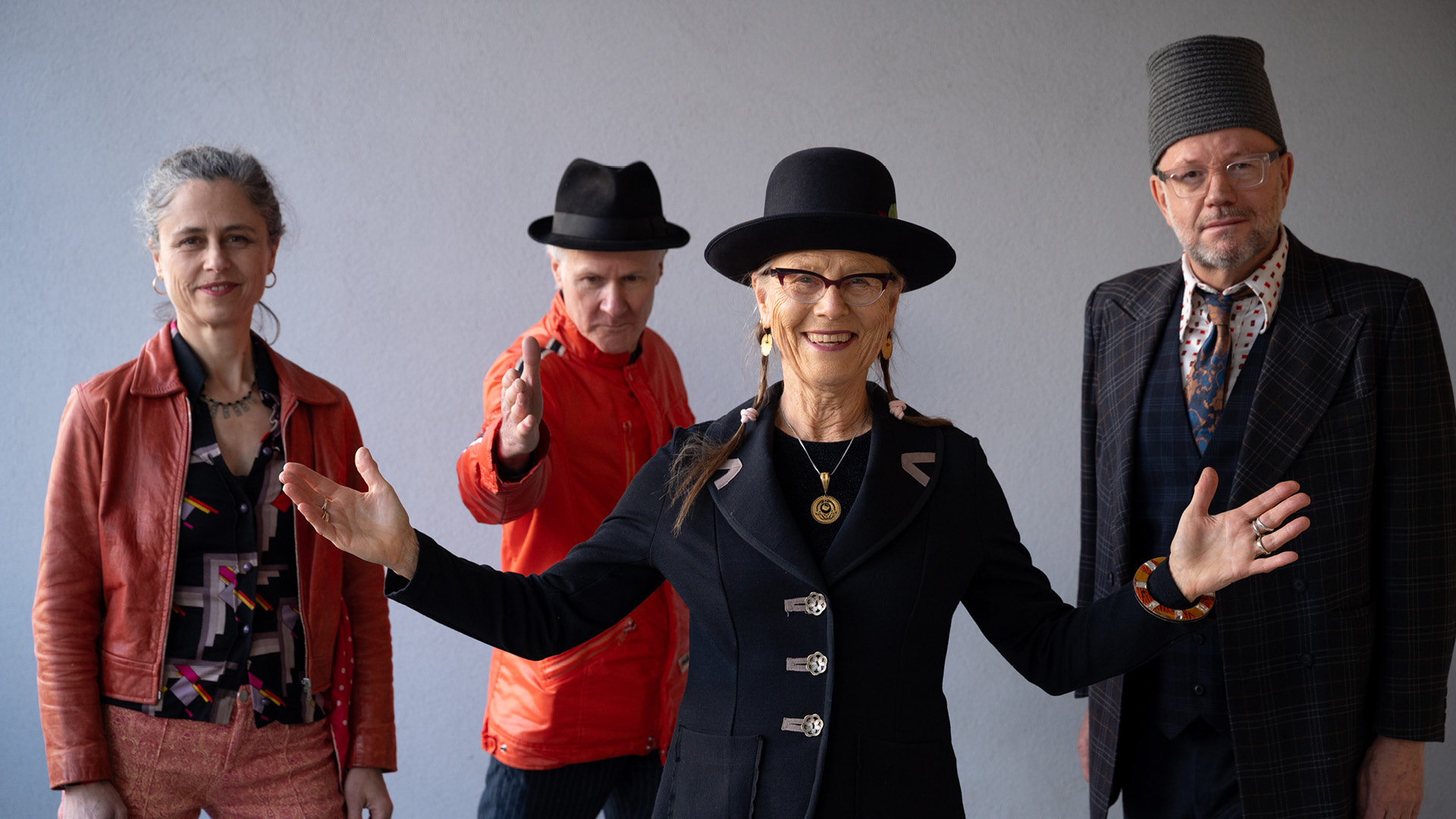 Four piece band, Sally Ford and the Idiomatics against a grey background.
