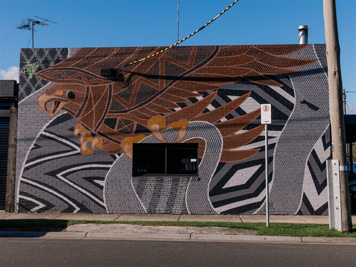 Artist Tommy Day's mural for Wall to Wall Festival 2024. A brown Wedge Tail Eagle swooping over black and white geometric patterns and linework.