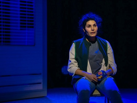 woman sitting on chair on grand hall stage - kingston city hall 